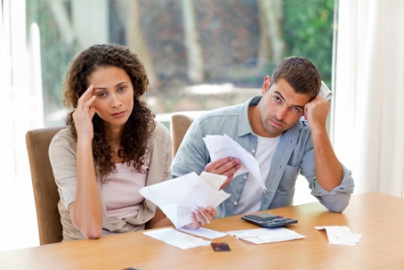 A couple reviewing documents with a look of stress